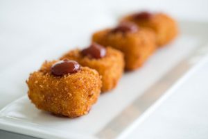 fried mac and cheese on a white plate